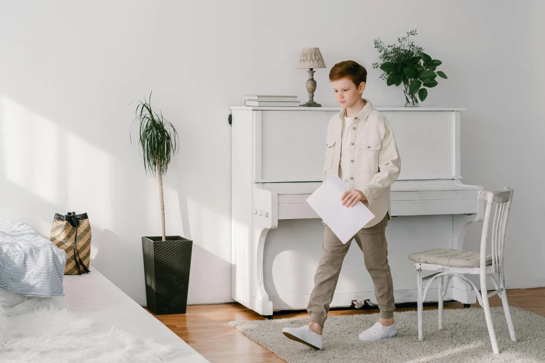 a man walking across a living room next to a piano, pexels contest winner, red haired teen boy, wearing a white button up shirt, holding a clipboard, full body with costume