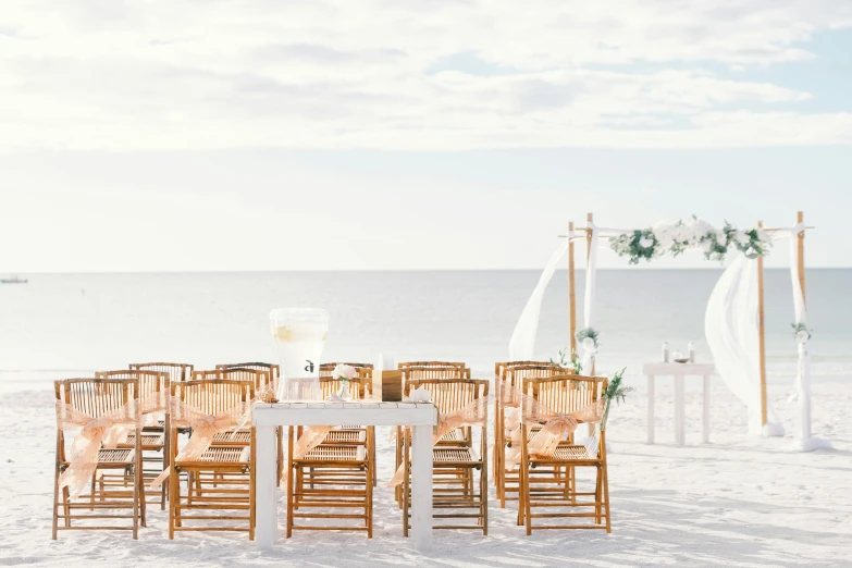 a group of chairs sitting on top of a sandy beach, on a white table, linen, backdrop, white sand beach