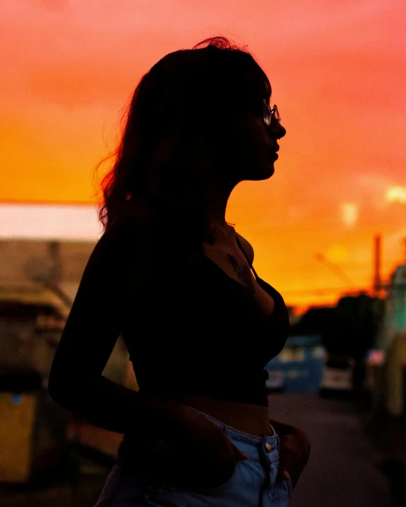 a woman standing in a parking lot at sunset, by Olivia Peguero, pexels contest winner, transgender, sexy :8, profile image, standing in a township street