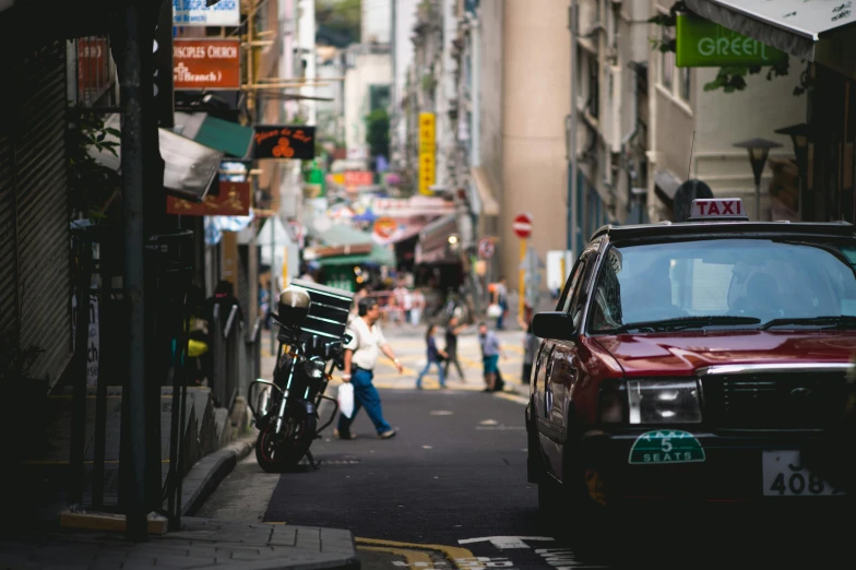 a red car parked on the side of a street, pexels contest winner, streets of hong kong, person in foreground, shady alleys, street signs