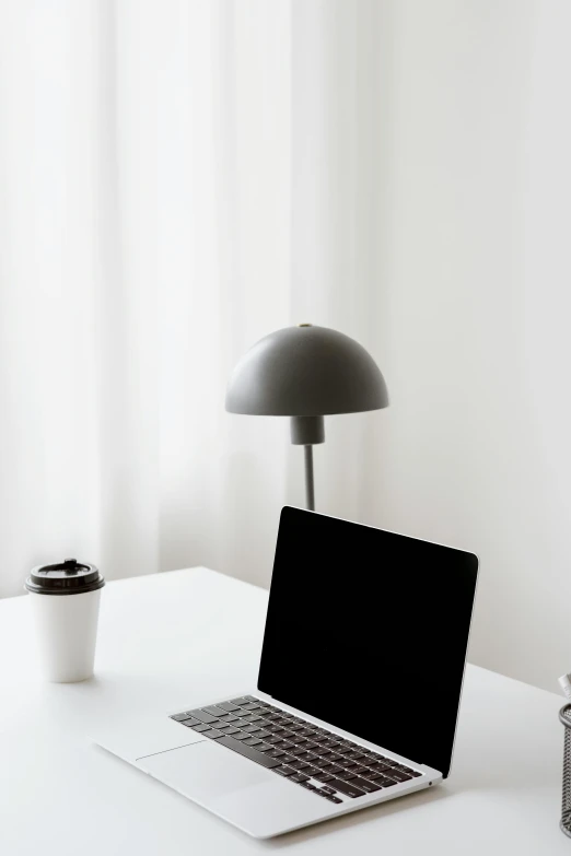 a laptop computer sitting on top of a white desk, by Andries Stock, light and space, emerging from a lamp, jovana rikalo, instagram post, grey