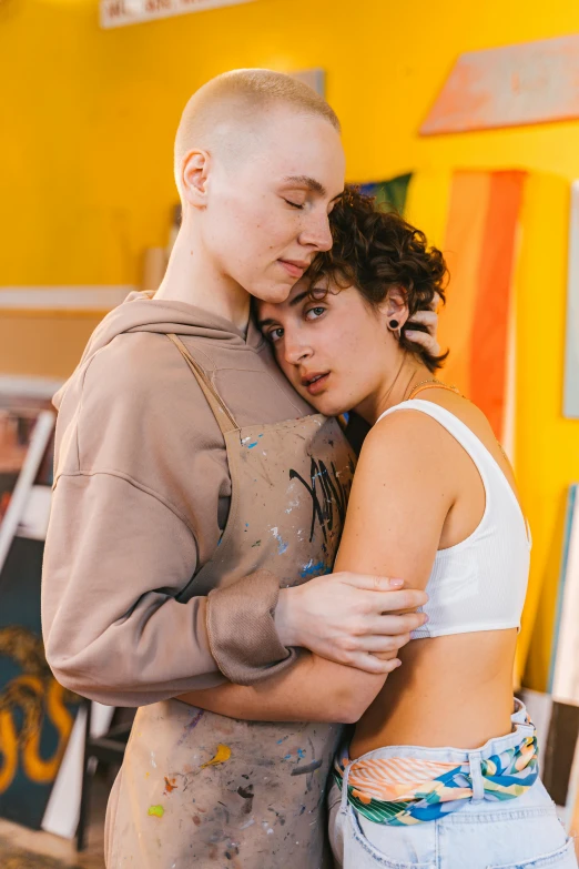 a man and a woman standing next to each other, a painting, trending on pexels, lesbian embrace, brown buzzcut, bella poarch, pastel'