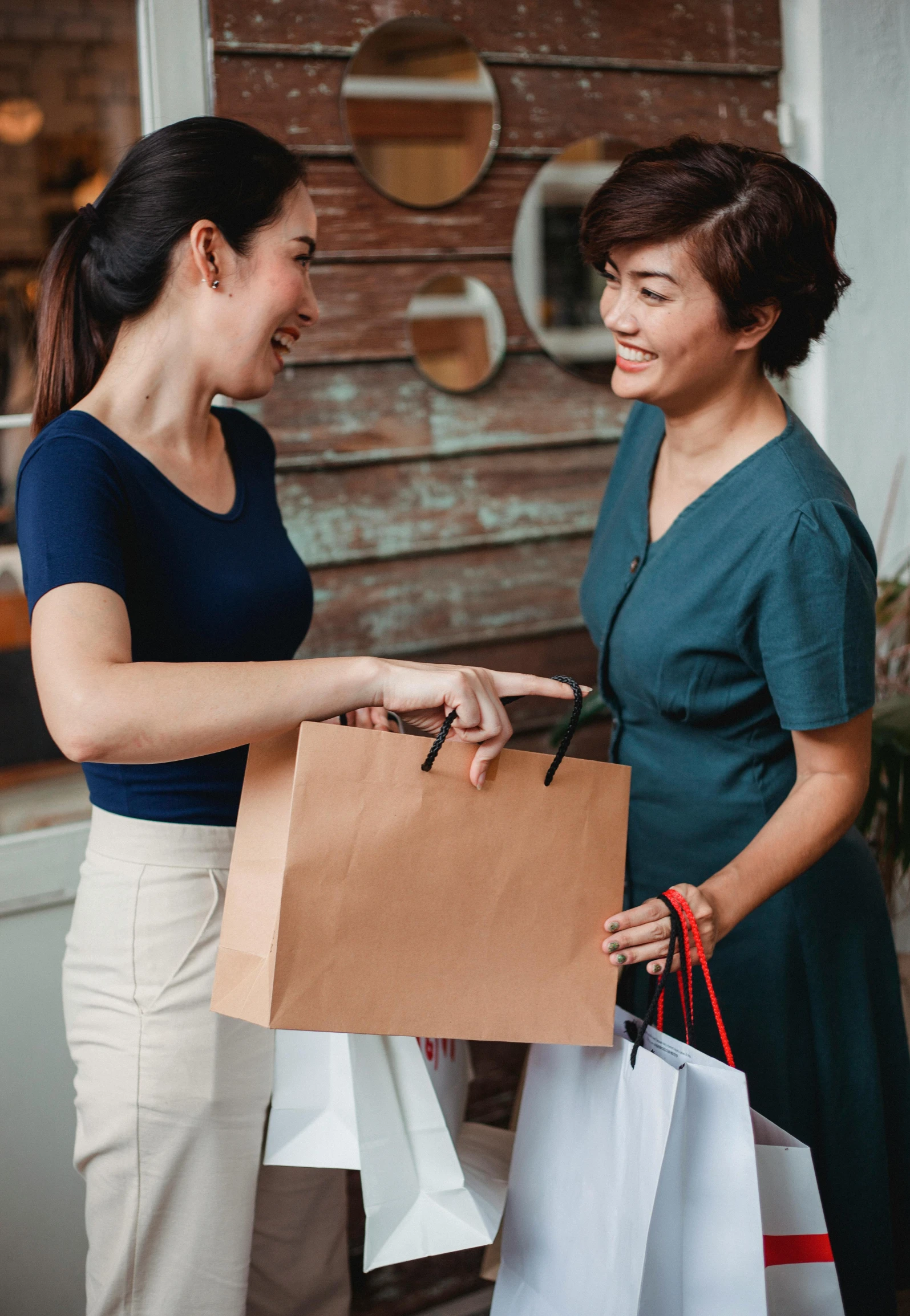 two women standing next to each other holding shopping bags, pexels contest winner, happening, smiling at each other, square, asian descent, on high-quality paper