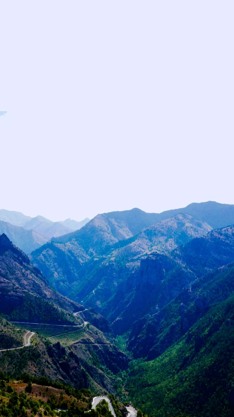 a view of a winding road in the mountains, an album cover, inspired by Li Keran, pexels, les nabis, panorama distant view, blue, uttarakhand, overexposed photograph