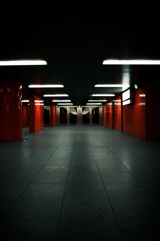 a long hallway in a building with red walls, an album cover, inspired by Thomas Struth, unsplash, postminimalism, subway station, dark night environment, square, kreuzberg