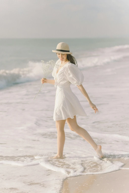 a woman in a white dress and hat walking on the beach, white fluffy cotton shorts, li zixin, swirling around, wearing a linen shirt