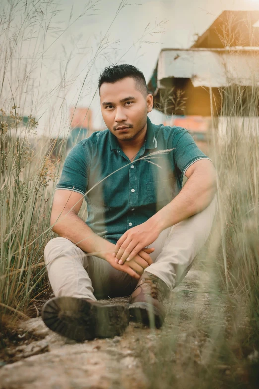 a man sitting in a field of tall grass, an album cover, inspired by Eddie Mendoza, pexels contest winner, sumatraism, handsome, portrait of danny gonzalez, grainy low quality, sittin