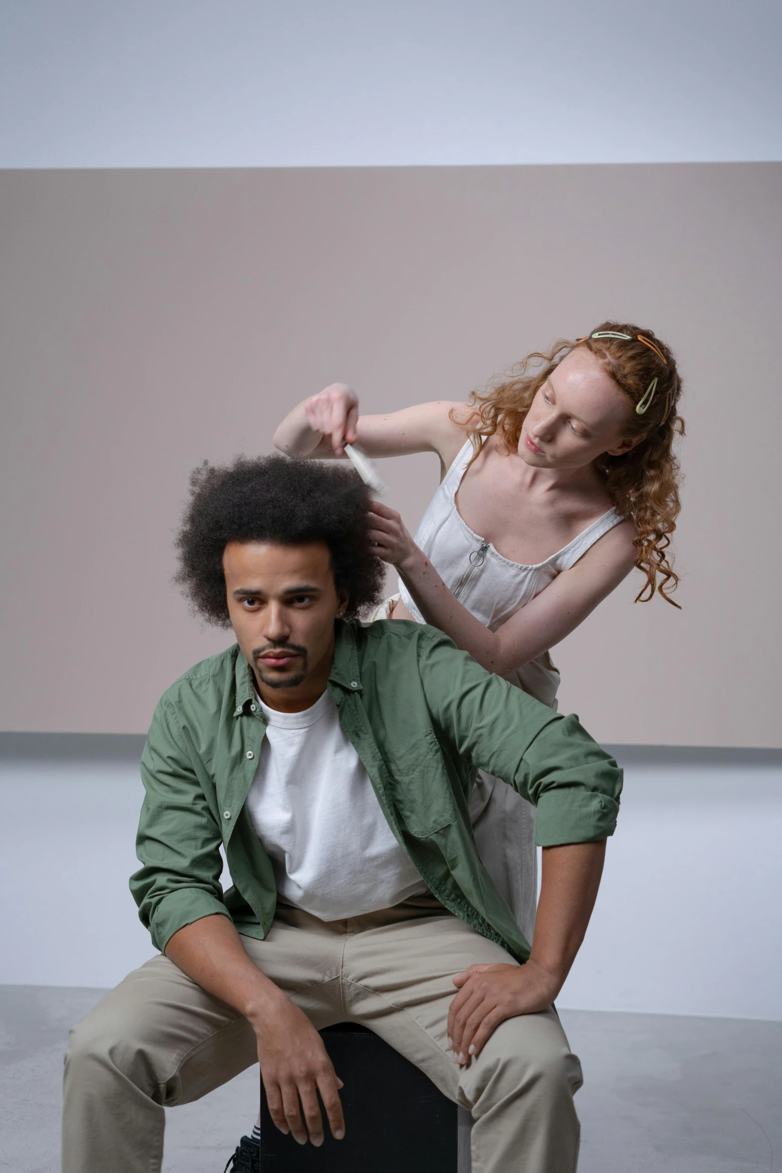 a man sitting on top of a suitcase next to a woman, inspired by Anna Füssli, renaissance, curly afro, production photo, touching heads, bedhead