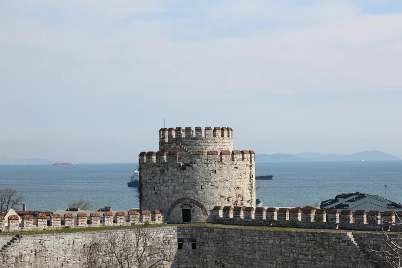 a castle sitting on top of a hill next to the ocean, istanbul, circular gate in a white wall, slide show, exterior