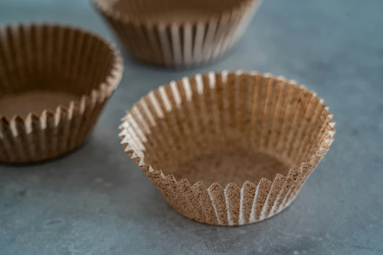 a couple of cups sitting on top of a table, sugar sprinkled, sustainable materials, brown:-2, frill