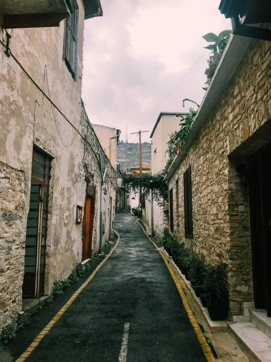 a narrow street is lined with stone buildings, by Alexis Grimou, vsco, christina kritkou, 90's photo