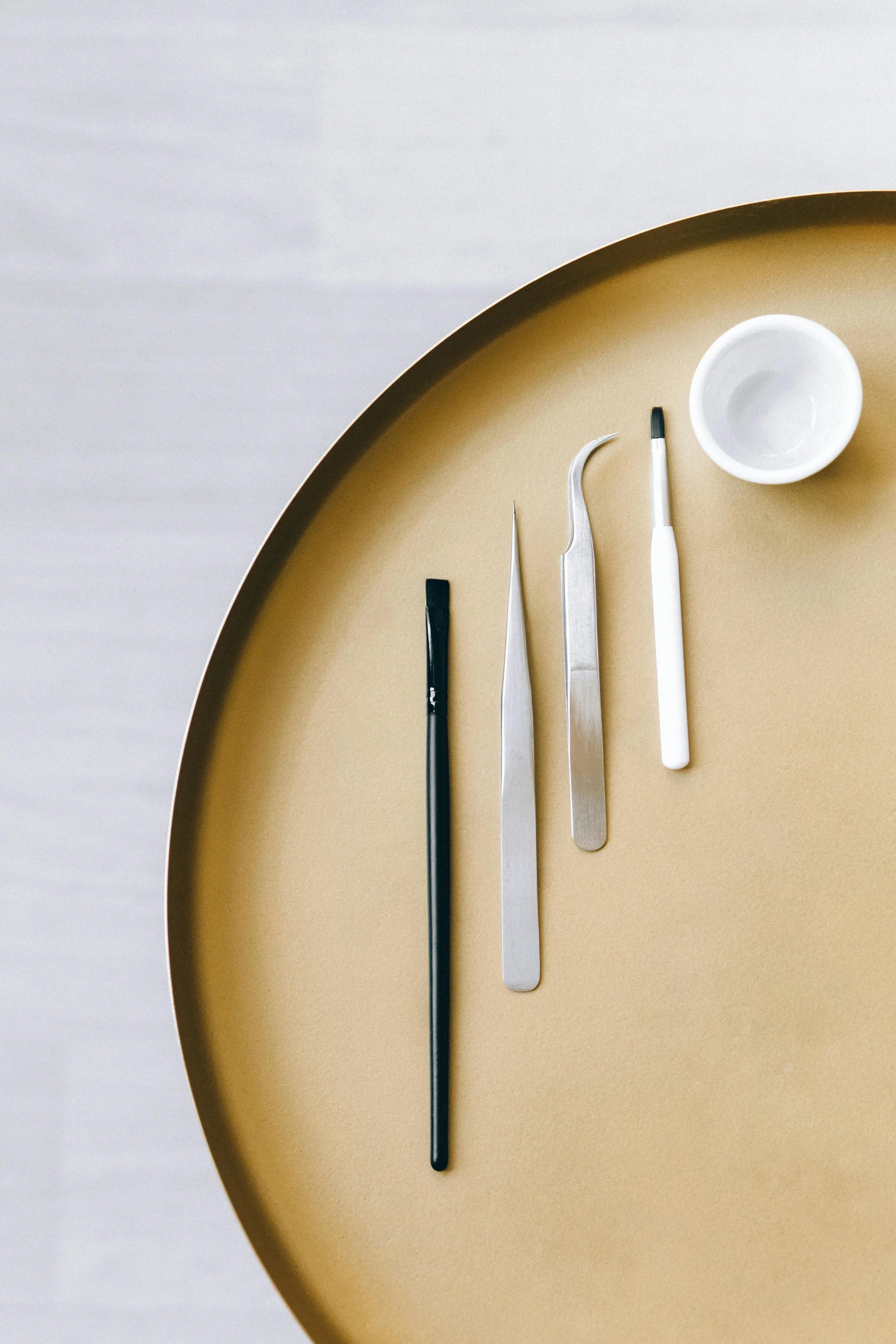 a close up of a plate with utensils on it, a still life, inspired by Kanō Naizen, trending on unsplash, minimalism, surgical implements, makeup, smooth and clean vector curves, surgical supplies