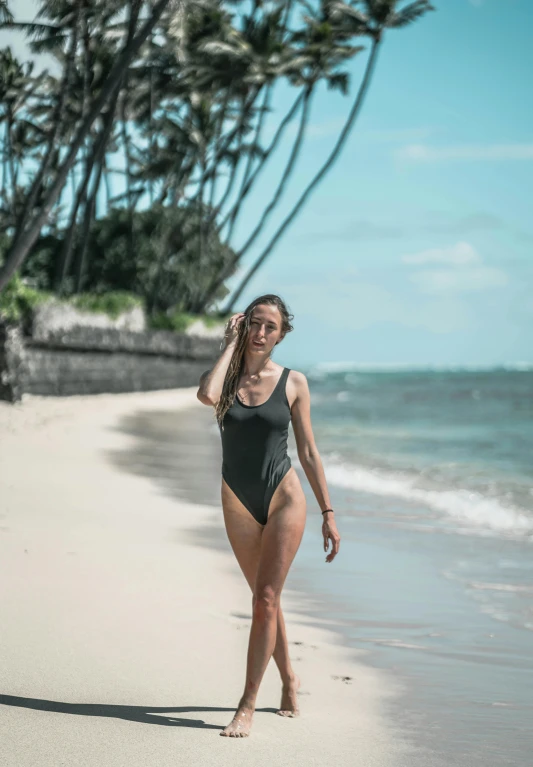 a woman walking on a beach next to the ocean, kaki body suit, hawaii, grey, 5 0 0 px models