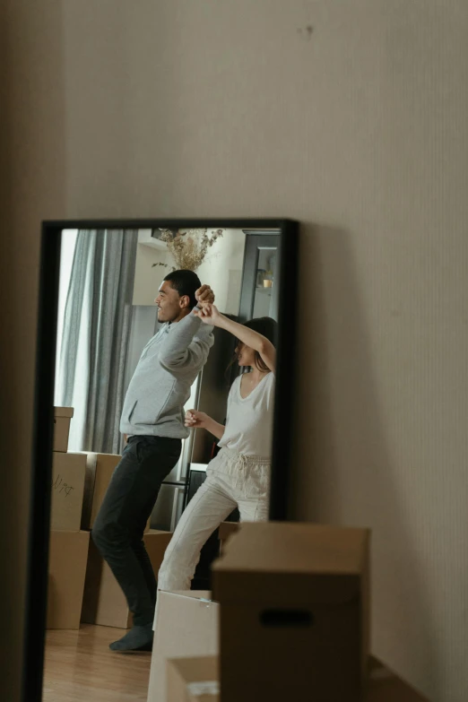 a man and a woman standing in front of a mirror, moving, location in a apartment, promo image, dancing