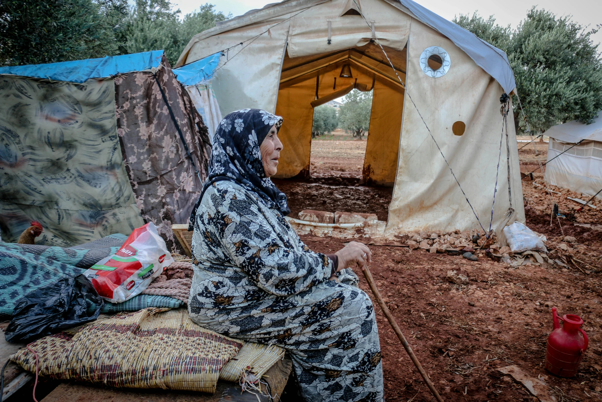 a woman sitting on a bed in front of a tent, by Meredith Dillman, hurufiyya, hideen village in the forest, demolition, watch photo, 15081959 21121991 01012000 4k