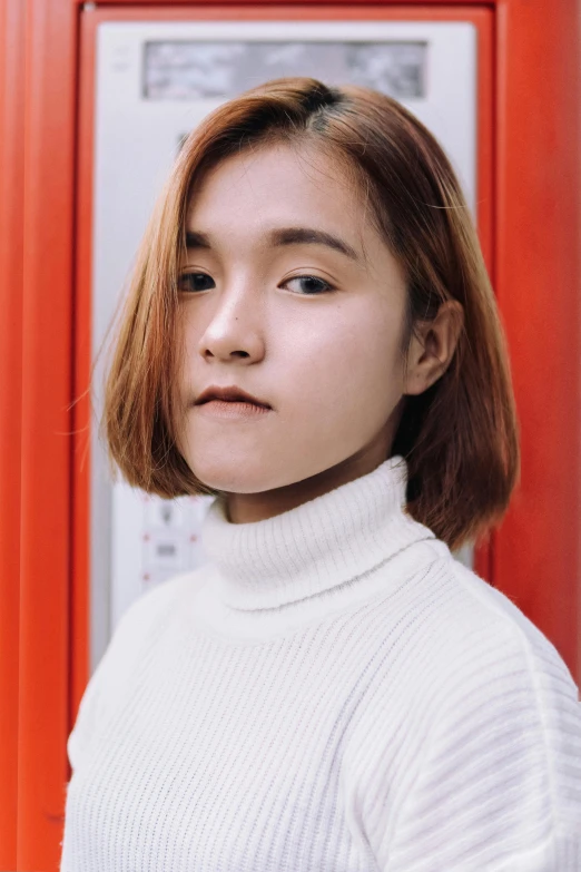 a woman standing in front of a red door, a character portrait, inspired by Kim Jeong-hui, trending on unsplash, realism, in white turtleneck shirt, chrome bob haircut, close - up studio photo, square face