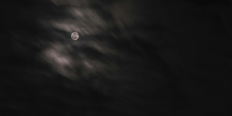 a full moon is seen through the clouds, a black and white photo, pexels contest winner, minimalism, night sky; 8k, cold stormy wind, yellowish full moon, atmospheric artwork