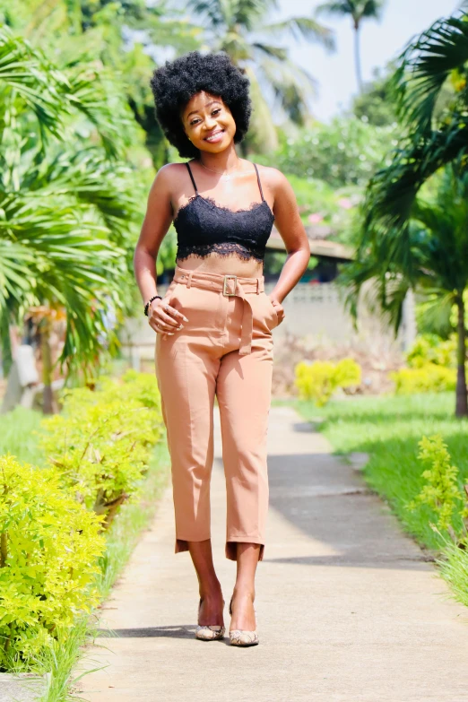 an image of a woman walking down a path, brown pants, croptop, satisfied pose, imane anys