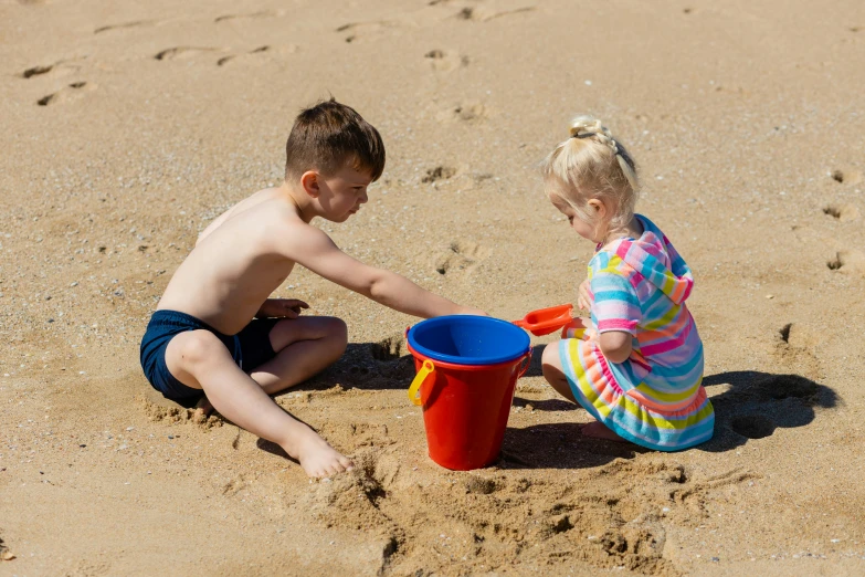 a boy and a girl playing in the sand, by Arabella Rankin, pexels contest winner, 15081959 21121991 01012000 4k, mid view, thumbnail, medium height