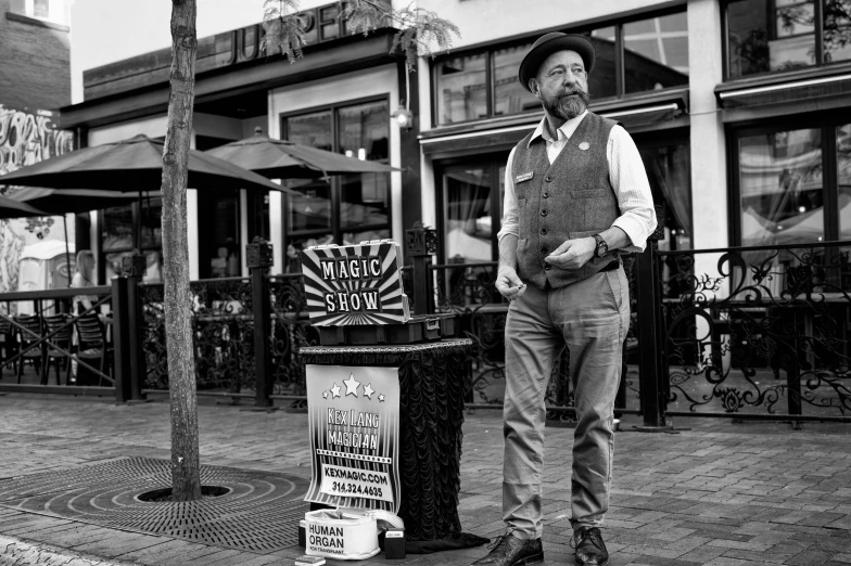 a black and white photo of a man standing on a sidewalk, inspired by Thomas Nast, magical realism, cardistry, presenting magic gem, at high noon, fish man