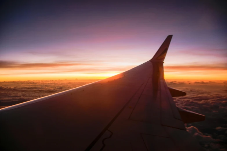 the wing of an airplane flying above the clouds, pexels contest winner, sunset glow, fan favorite, tail fin, airplanes