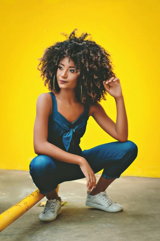 a woman sitting on top of a baseball bat, trending on pexels, renaissance, wavy hair yellow theme, she has olive brown skin, wearing blue jean overalls, profile image