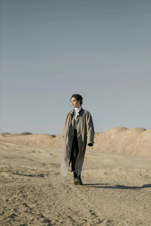 a man and a woman walking in the desert, an album cover, inspired by Peter Lindbergh, unsplash, neo-romanticism, trench coat, sangsoo jeong, portrait of timothee chalamet, kurdish lawyer