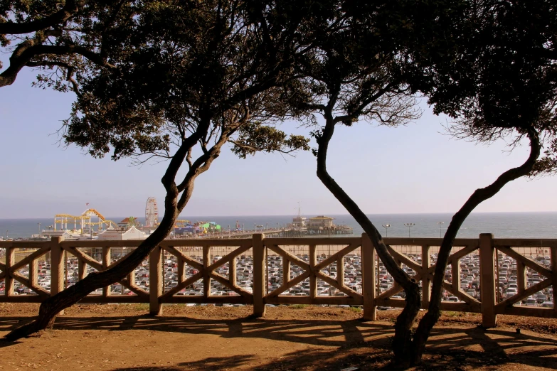 a bench that is next to some trees, by Carey Morris, unsplash, hurufiyya, santa monica beach, as seen from the canopy, tehran, 2000s photo