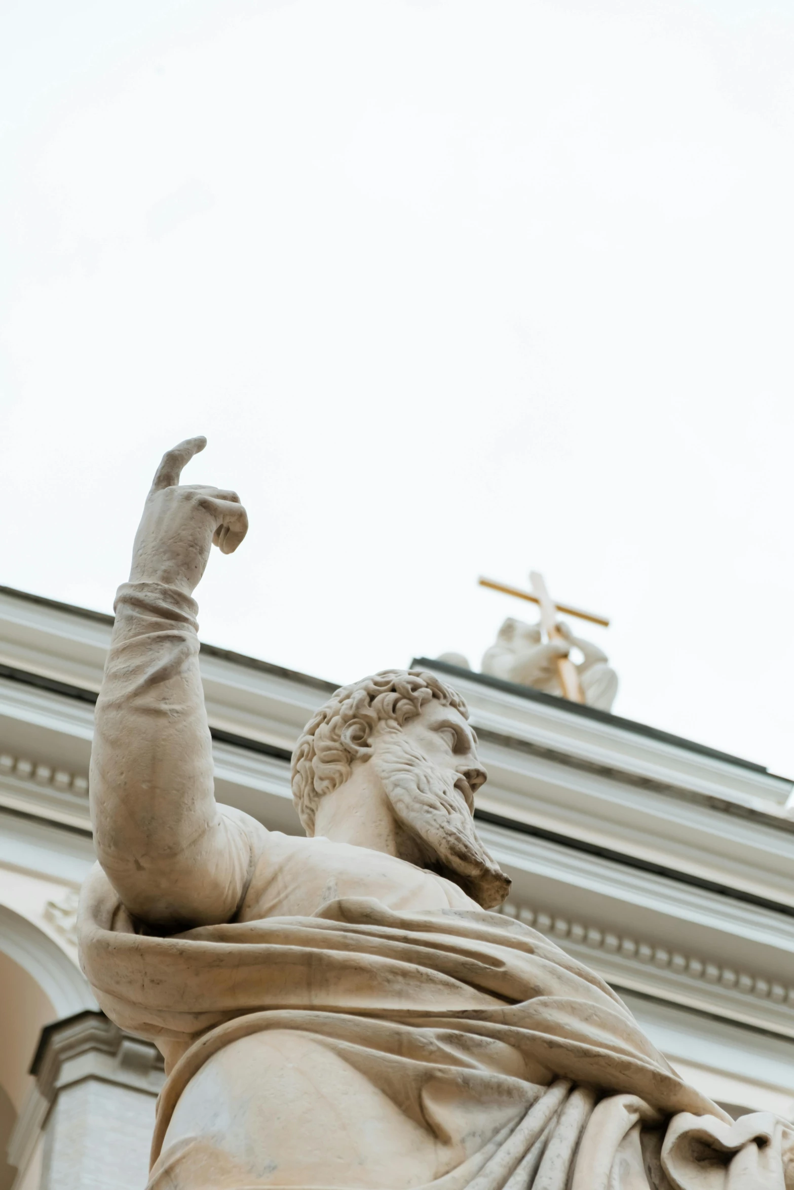 a statue of a man on top of a building, a statue, inspired by Cagnaccio di San Pietro, trending on unsplash, neoclassicism, orthodox icons, half image, with arms up, golden detailing