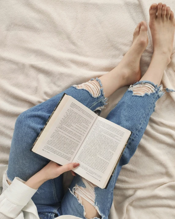 a person laying on a bed reading a book, by Isabel Naftel, pexels contest winner, wearing jeans, wearing torn clothes, gif, old testament