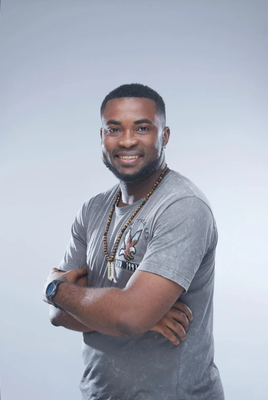 a man standing with his arms crossed, by Chinwe Chukwuogo-Roy, happening, on a gray background, confident smirk, trending arstationhq, headshot profile picture