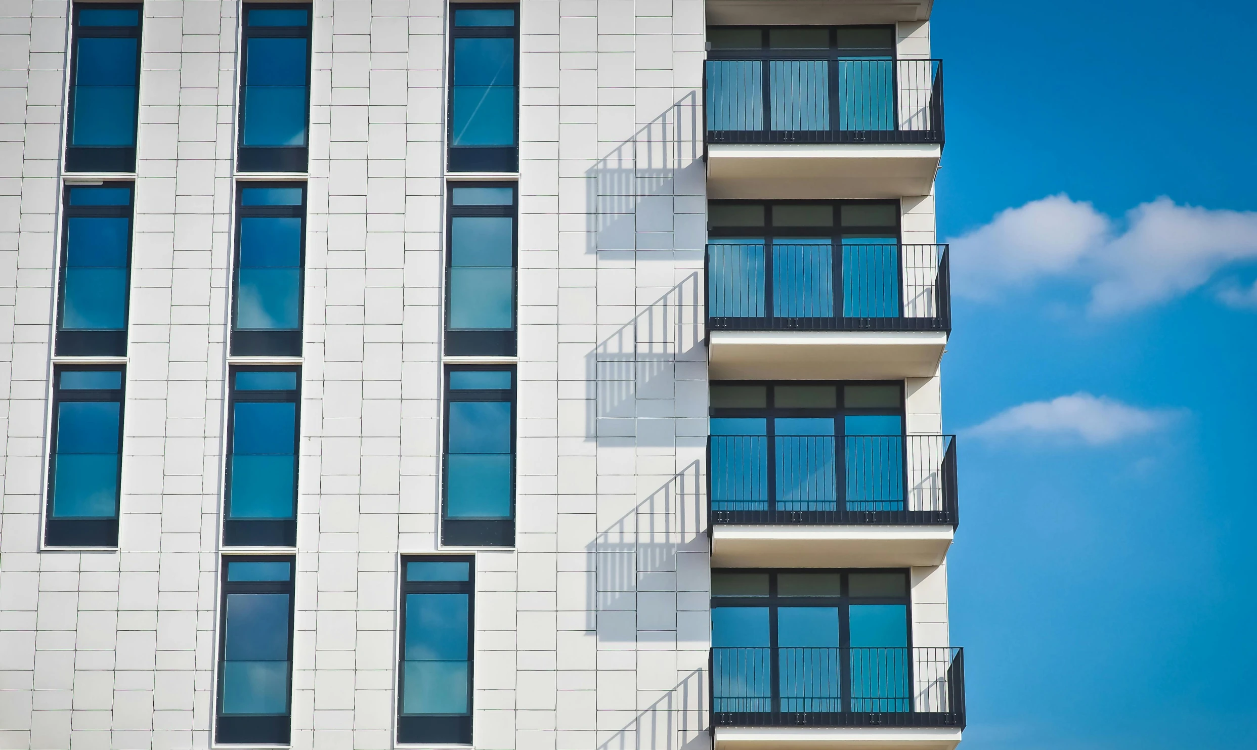 a tall white building with many windows and balconies, pexels, bauhaus, steel window mullions, stockphoto, multiple stories, archviz