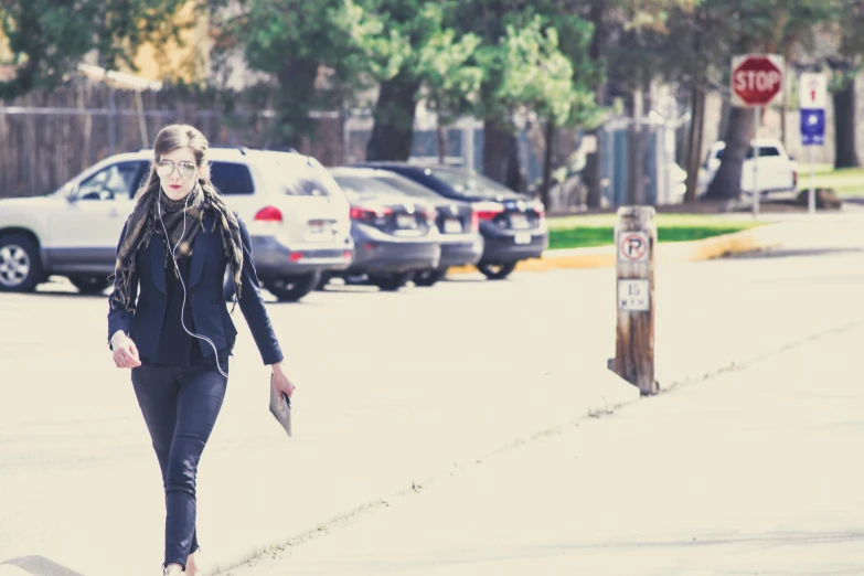 a woman walking down a street with a skateboard, unsplash, people at work, background image, lynn skordal, walking through a suburb