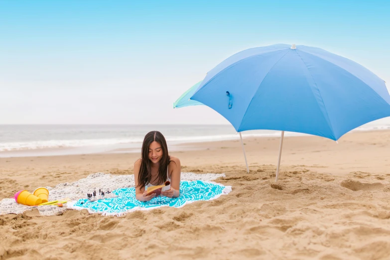 a girl laying on the beach under a blue umbrella, unsplash, light blue, slide show, standing with a parasol, circular