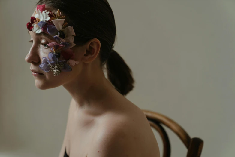 a woman with flowers painted on her face, an album cover, by Emma Andijewska, trending on pexels, soft light from the side, wearing facemask, ignant, recital