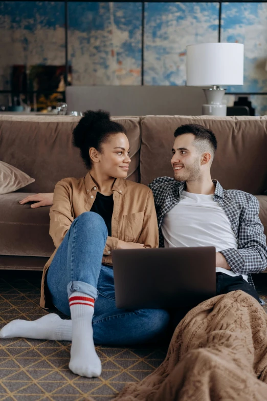 a man and woman sitting on a couch with a laptop, trending on pexels, renaissance, lesbians, diverse outfits, romantic lead, brown