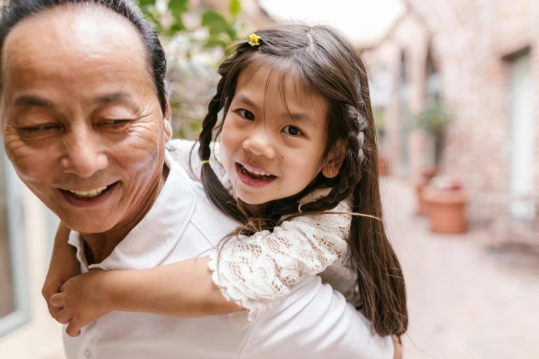 a man carrying a little girl on his shoulders, pexels contest winner, asian face, grandfatherly, smiling girl, profile image