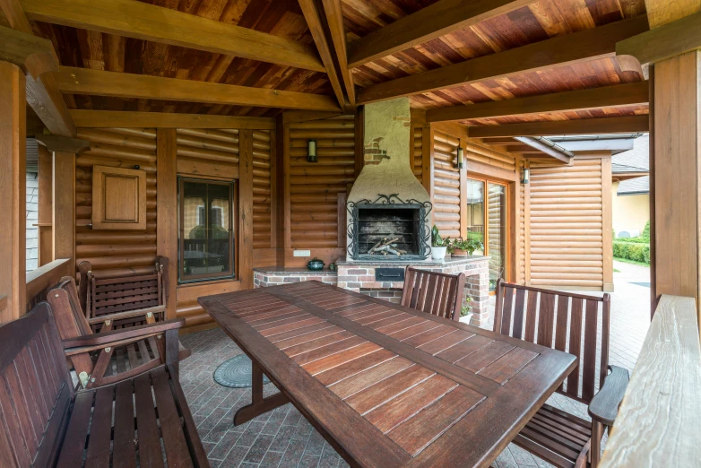 a wooden table sitting on top of a patio, a portrait, by Alexander Fedosav, shutterstock, luxurious wooden cottage, located in hajibektash complex, with a front porch, fireplace