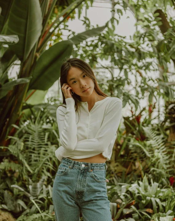 a woman standing in a greenhouse talking on a cell phone, an album cover, unsplash contest winner, sumatraism, wearing a white button up shirt, asian girl, tinyest midriff ever, lush foliage