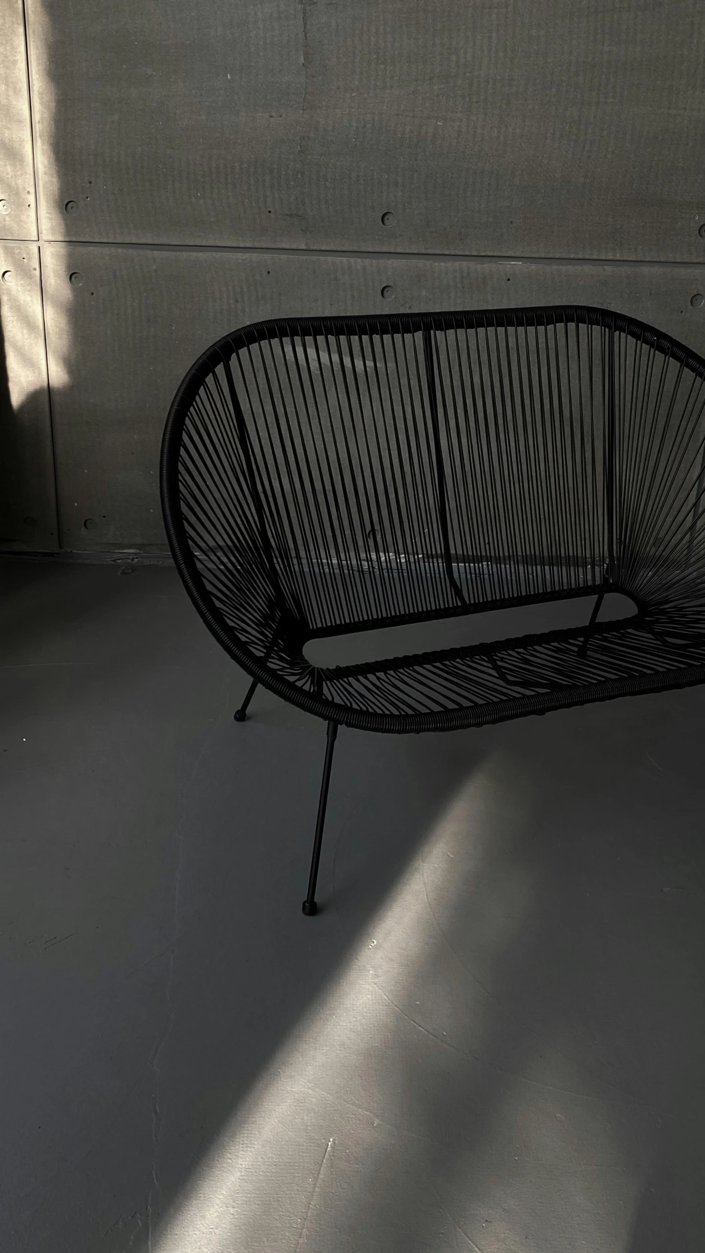 a black chair sitting on top of a white floor, outside on the ground