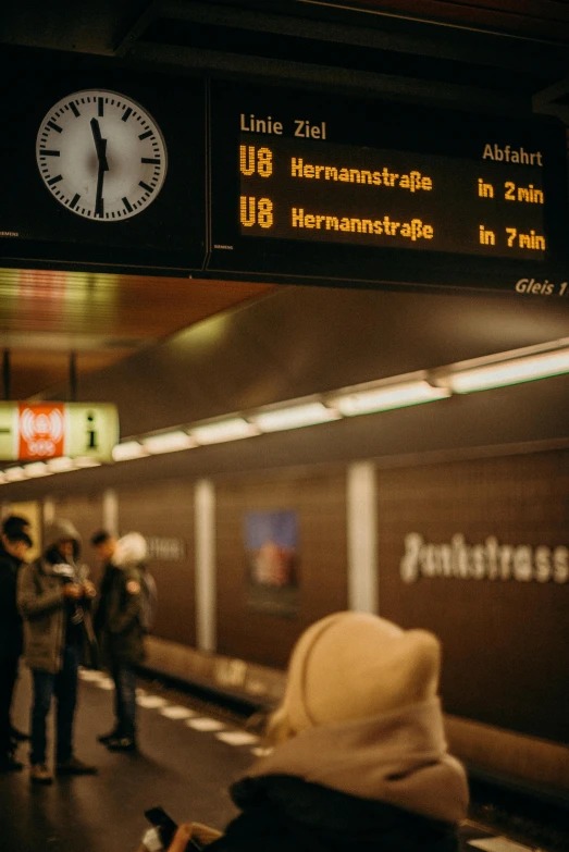 a group of people waiting at a train station, a picture, by Kristian Zahrtmann, unsplash, digital display, german, illuminated, hsv