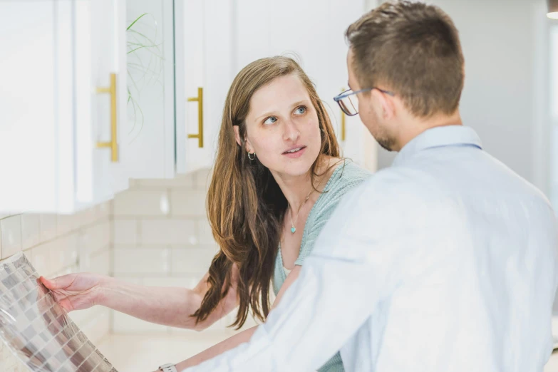 a man and a woman looking at a newspaper, by Jacqui Morgan, unsplash, pristine clean design, instagram picture, nursing, looking to his side