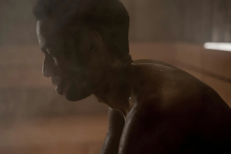 a man sitting in a sauna with steam coming out of his face, inspired by Gordon Parks, pexels contest winner, figuration libre, brown skin like soil, soft light from the side, movie frame still, covered in dirt