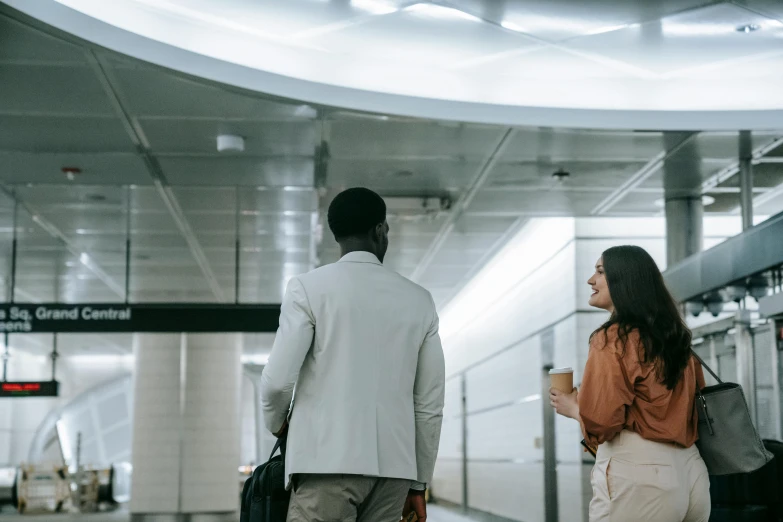 a man and a woman walking through an airport, pexels contest winner, happening, office ceiling panels, meeting point, underground facility, two characters