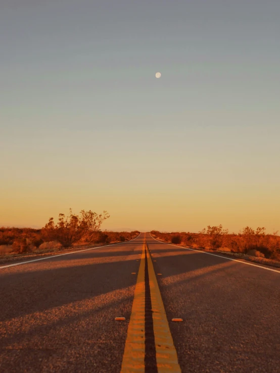 an empty road in the middle of the desert, by Lee Loughridge, unsplash contest winner, australian tonalism, with the moon out, cloudless sky, in style of joel meyerowitz, golden hour 4k