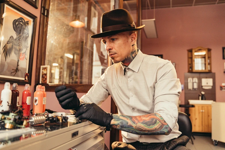 a man getting a tattoo at a tattoo parlor, by Meredith Dillman, pexels, a suited man in a hat, avatar image, thumbnail, confident looking