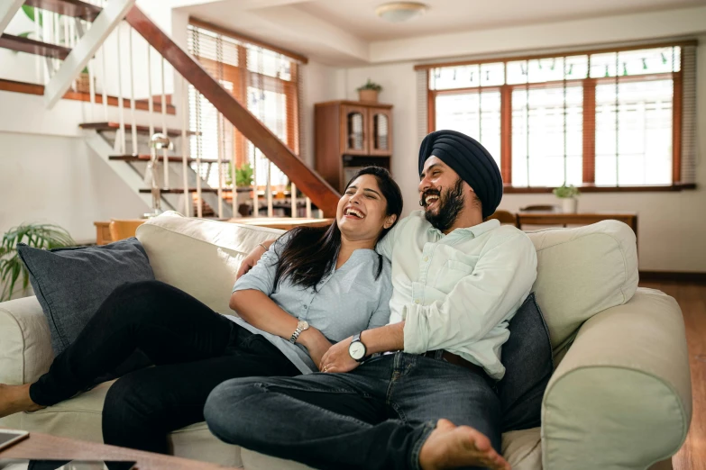 a man and woman sitting on a couch laughing, inspired by Manjit Bawa, happening, watching tv, australian, **cinematic, single image