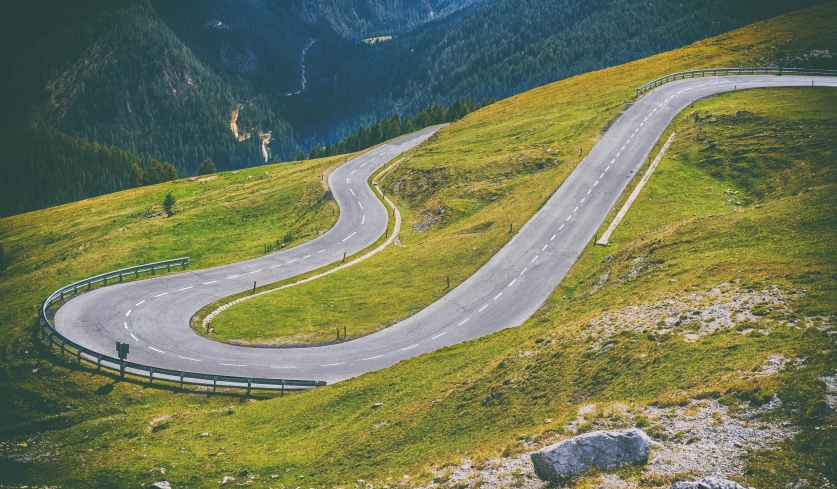 a winding road in the mountains with mountains in the background, pexels contest winner, 9 9 designs, top down, flat curves, 🚿🗝📝