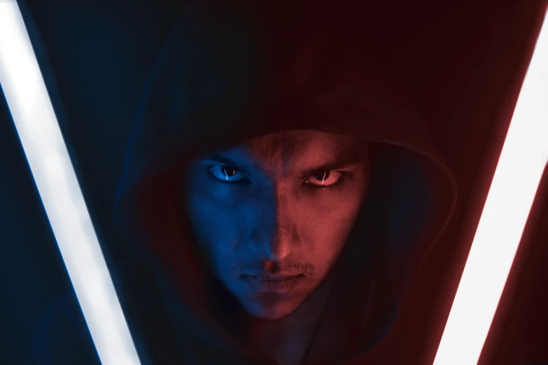 a man in a hoodie holding a light saber, a character portrait, by Adam Marczyński, shutterstock, attractive symmetrical face, red and blue black light, close up portrait photo, battle between good and evil