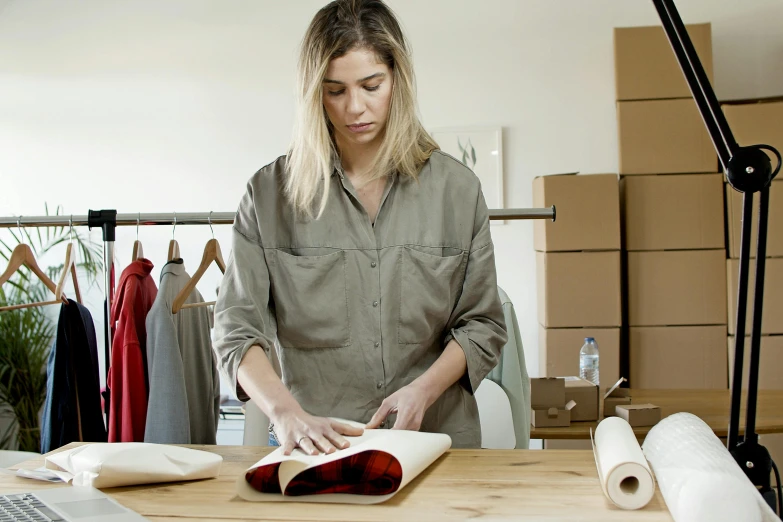 a woman that is standing in front of a laptop, inspired by Sarah Lucas, trending on unsplash, process art, folds of fabric, inspect in inventory image, cardboard, professionally detailed